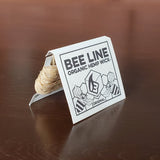 Bee Line Organic Hemp Wick packaging on a wooden surface