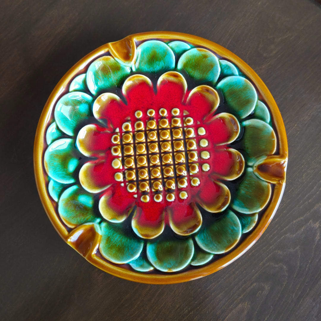 Decorative ceramic dish with a colorful floral pattern on a dark surface