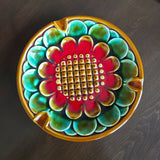 Decorative ceramic dish with a colorful floral pattern on a dark surface